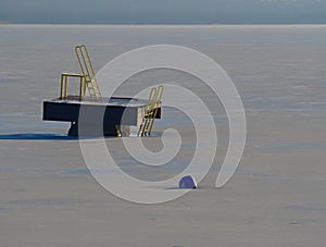 Swimming resort lake with ice in winter sunny day. Abandoned pool