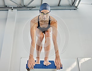 Swimming, sports and woman jump in pool for exercise, training and workout for competition in gym. Fitness, diving and