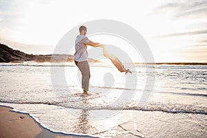 Swing, beach and father with playing child holding hands in nature for freedom or bonding at sunset. Ocean, travel and