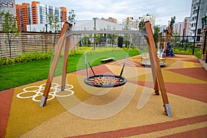 Swing on a beautiful rubberized covering in the form of triangles on the playground in kindergarten