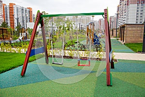 Swing on a beautiful rubberized covering in the form of triangles on the playground in kindergarten