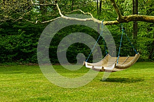 Swing bench in lush garden photo