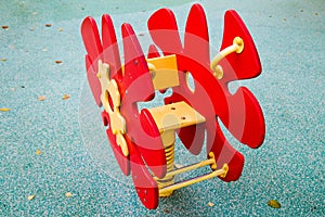 Swing bright red in the form of a flower on the Playground with a rubberized coating. Kids games sports