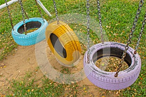 Swing chairs made from old tires for children in park.