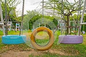 Swing chairs made from old tires for children in park.