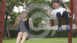 Swing child mother on playground playing