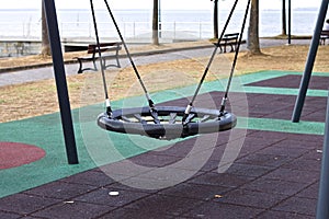 A swing on a children`s playground in a public park Umbria, Italy
