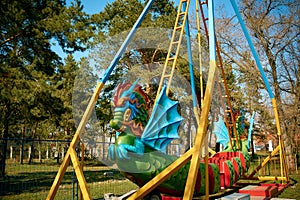 Swing in the form of a dragon in the children`s Park