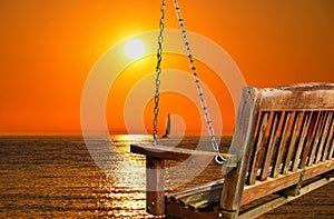 Swing with lake sunset and sailboat