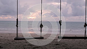 swing near white sand beach with coconut tree in thailand with sunny summer weather while sunset vanilla sky time