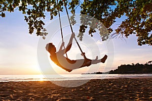 Swing on paradise tropical beach at sunset