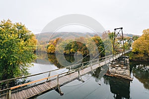 Swinging bridge over the James River and fall color in Buchanan, Virginia