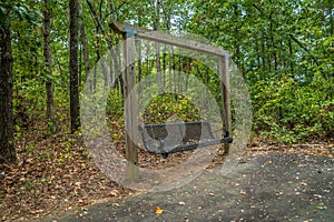 Swinging park bench in the woods