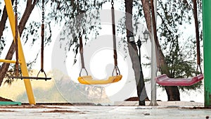 swings in the playground . Empty swings swayed by the sea breeze. missing child and kidnapping concept