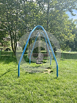 Swings in the playground with park in the background