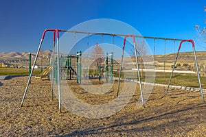 Swingset with empty swings at playground in Utah