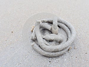 Swirl of sand and mud on the beach cast by lug or sand worms with sediment balls or pellet made by ghost or sand crab