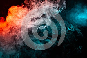 Swirling insulated colored smoke: blue, red, orange, pink; Scrolling on a black background in the dark close up. Concept design w