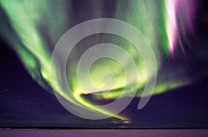 Swirling Northern Lights and Stars over Frozen Lake