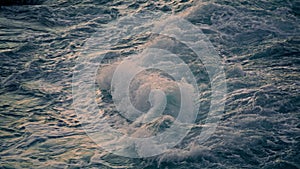 Swirling ocean foaming at morning nature closeup. Waves breaking at shoreline