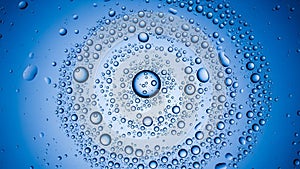 Swirling pattern of water droplets on blue surface creating a cosmic vortex effect