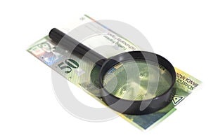 Swiss 50 Franc banknotes under magnifying glass