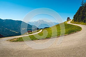 Swiss alpine panorama with u-turn mountain road and green pastures