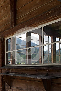 Swiss Alps behind a window of a wooden house