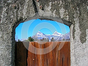 The Swiss Alps through a vineyard gate