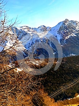 Swiss Alps in winter. Snowy mountain peaks followed by the browny wildness