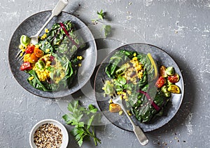 Swiss chard packets. Chard leaves stuffed with turmeric lentils and vegetables. Vegetarian healthy food concept. On a grey backgro