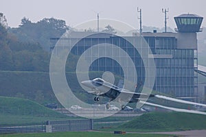 Swiss F18 aircraft takes off with the air traffic control tower in the background