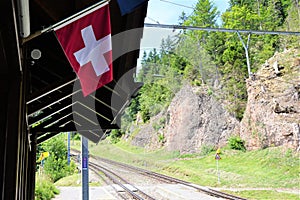 Swiss flag hanging from eaves on outdoor train platform