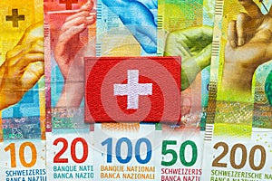 Swiss flag lying on banknotes, Swiss francs, Currency of Switzerland, business and financial concept