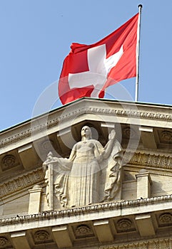 Swiss flag and statue of Justice on Federal Supreme Court of Switzerland. Lausanne, Switzerland
