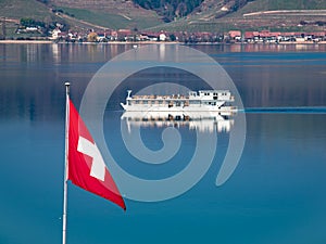 Swiss flag and a tourist boat on the Murtensee lake