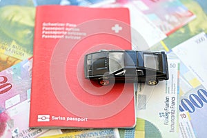 Swiss franc banknotes and toy car with passport. The current francs money bills and car with pass photo