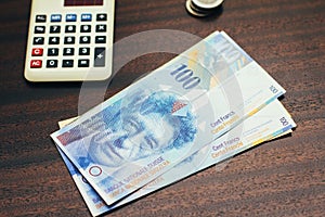 Swiss franc money and calculator finance concept