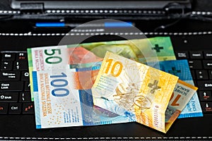 Swiss francs lying on a tablet keyboard, business e-commerce in Switzerland, Shopping and trading, Online market concept, analysis