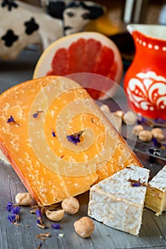 Swiss and holland cheese, decorative red pitcher, sliced grapefruit, hazelnut and flower