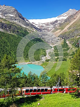 Swiss mountain train Bernina Express crossed Alps with glaciers in the summer photo