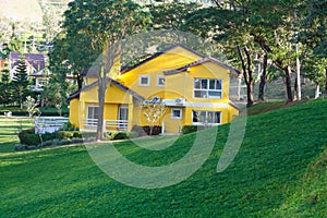 Swiss mountain valley landscape with a yellow house