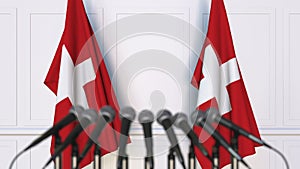 Swiss official press conference. Flags of Switzerland and microphones. Conceptual 3D rendering