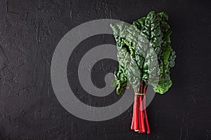 Swiss Rainbow chard, silverbeet or mangold over rustic blue textured background