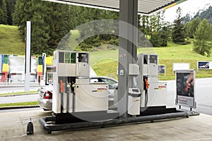 Swiss and traveler people fill oil to tank of car in petrol station