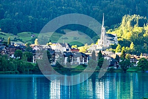 Swiss village Lungern on lake Lungerersee with traditional houses and old church