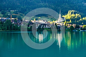 Swiss village Lungern on lake Lungerersee with traditional houses and old church