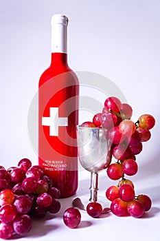 Swiss wine bottle, grapes and a silver cup