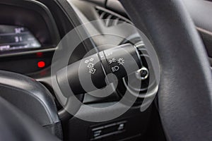 Switch off lights in a car. close-up Car integrated turning indicator with headlight switch toggle.