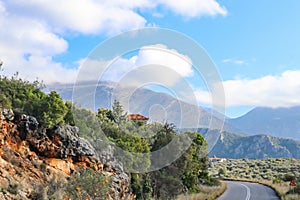 Switchback in paved two lane highway through the Taygetus mountain range on the Peloponnese in Greece with tile roofed houses